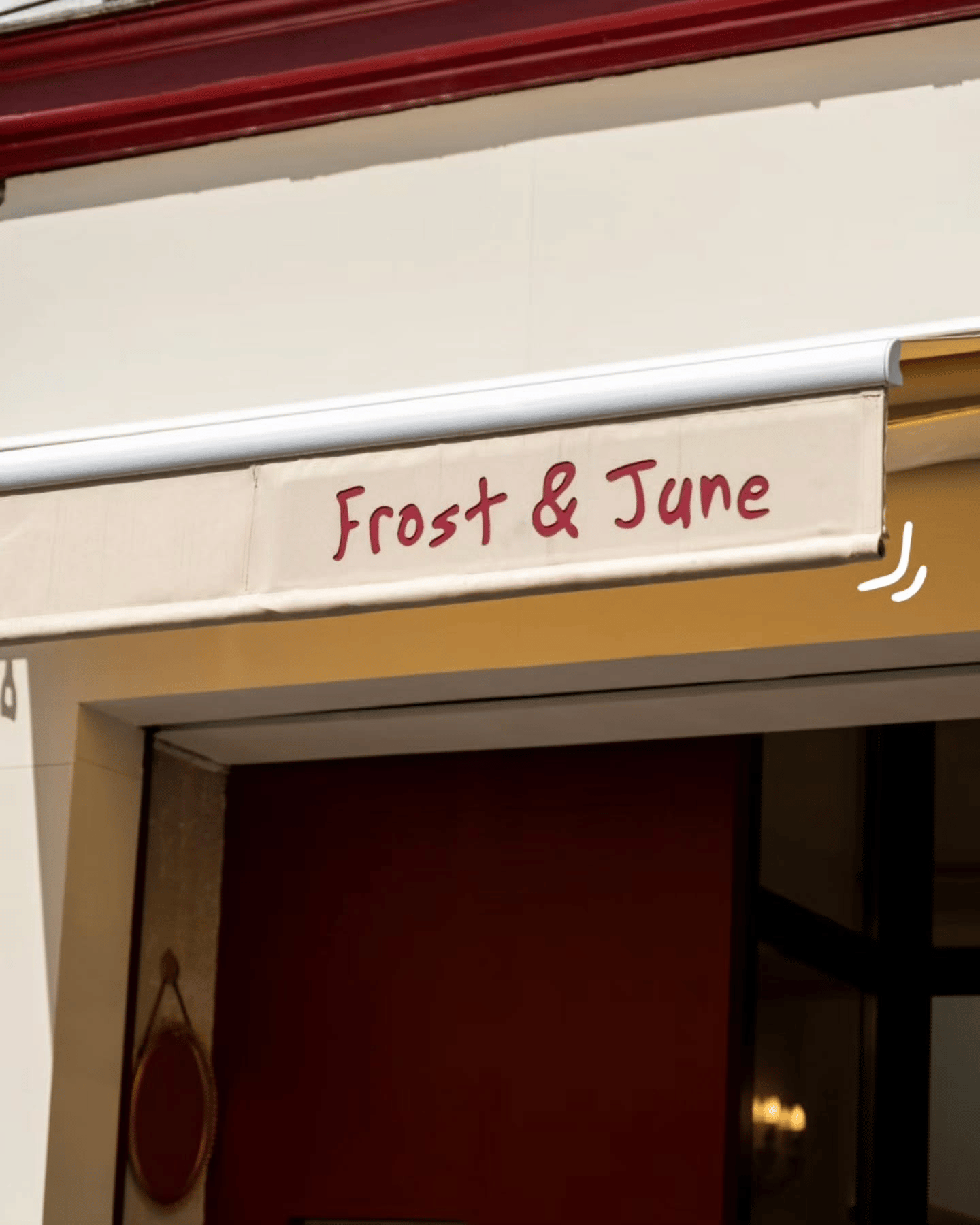 Store avec enseigne Frost & June en lettres bordeaux